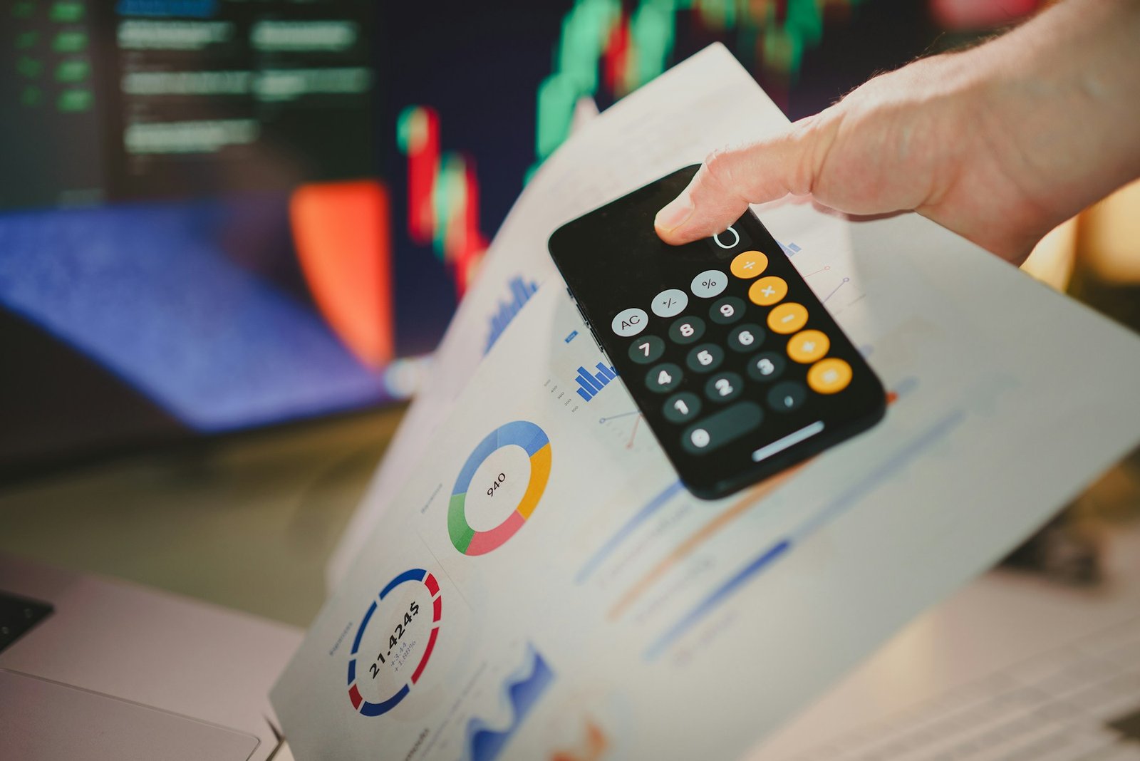 Financial figures and charts being reviewed with a calculator