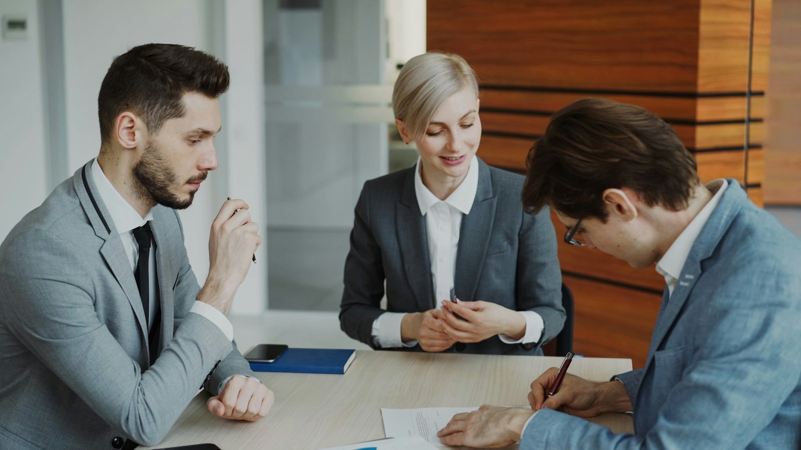 Legal professionals meeting with a client signing documents