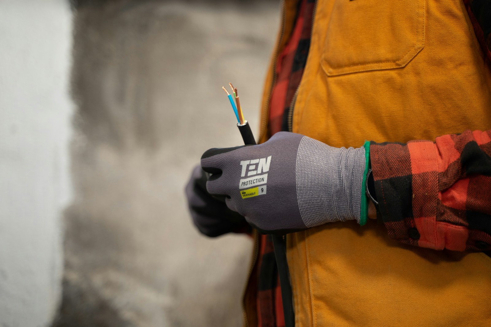 Electrician holding an exposed cable while working on site